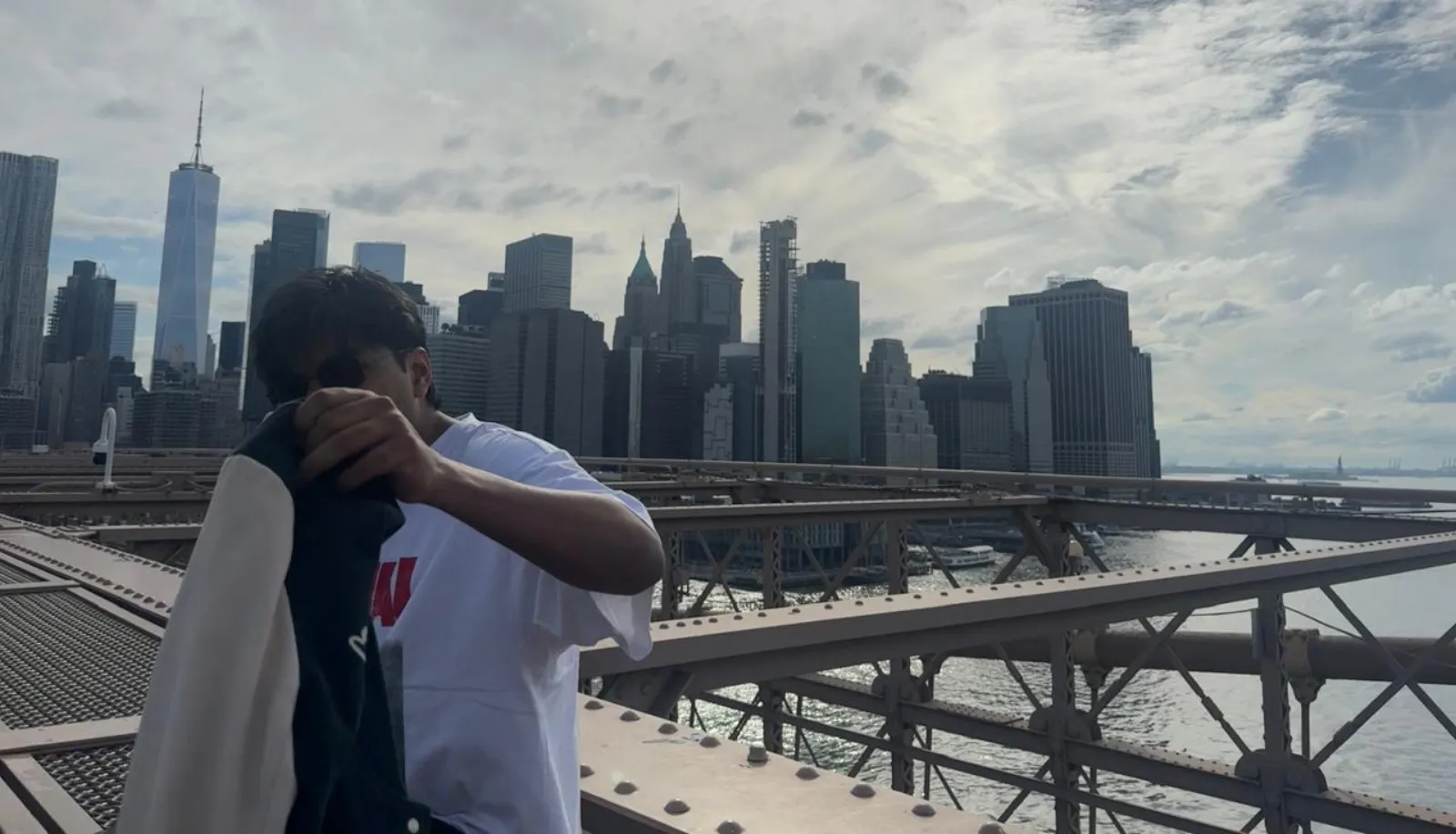 Arjun Agarwal on the Brooklyn Bridge, with the Manhattan skyline behind him